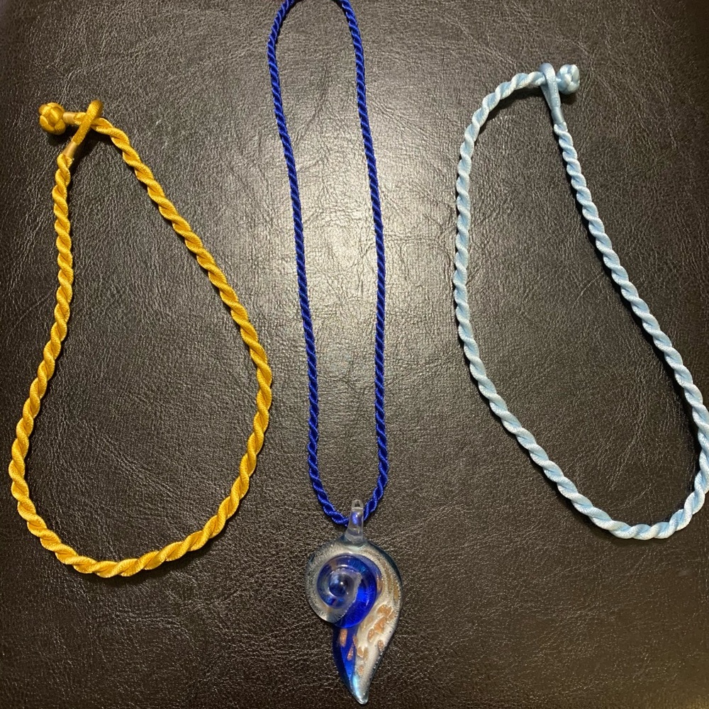 Glass pendant with interchangeable fabric rope necklaces.